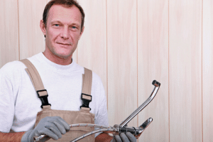 Experienced plumber holding plumbing tools, showcasing expertise in residential plumbing services, emphasizing quality and customer satisfaction.