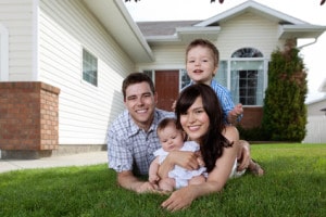 Family enjoying time outdoors in front of their home, emphasizing the importance of home maintenance and comfort.