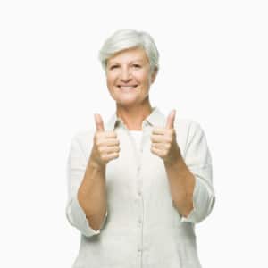 Smiling older woman giving a thumbs-up gesture, representing satisfaction with water treatment services.