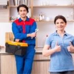 Technician and satisfied customer in a bright kitchen, showcasing plumbing tools for Allore's Plumbing Services LLC.