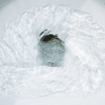 Whirlpool of clear, frothy water showcasing dynamic motion, related to plumbing maintenance tips for homeowners.