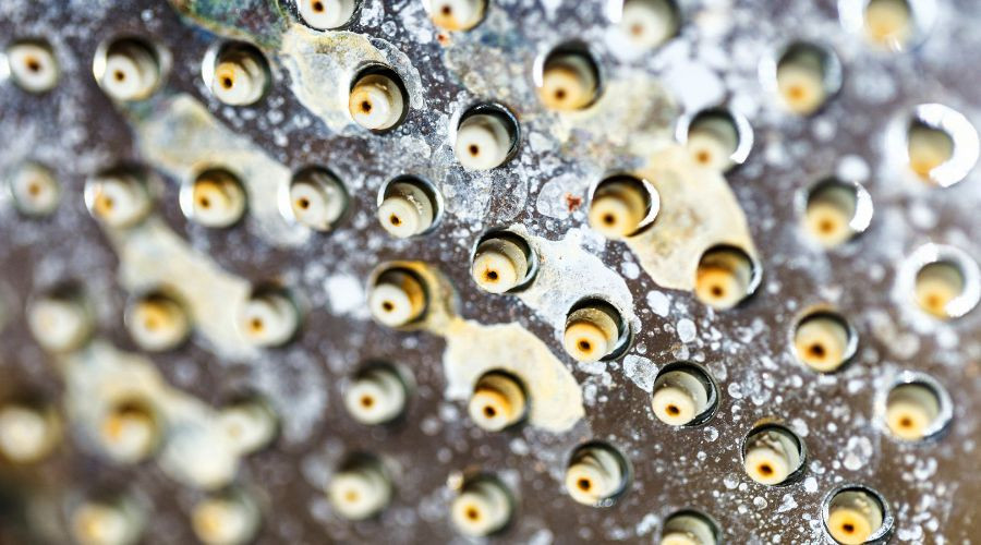 Close-up of a rusty metal grater, showcasing aged surface details relevant to plumbing maintenance.