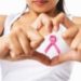 Woman's hands forming a heart shape with a pink ribbon, symbolizing breast cancer awareness—Allore's Plumbing Services.