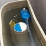 Toilet tank mechanism with float valve and plumbing parts, illustrating plumbing maintenance by Allore's Plumbing Services.