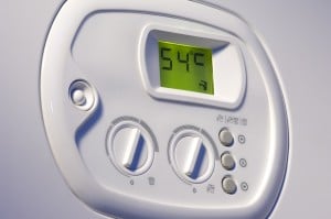 Water heater control panel displaying temperature setting at 54°C, relevant for energy conservation tips before vacation.