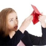 Young woman looking surprised with an open red wallet, reflecting financial uncertainty related to plumbing service costs.