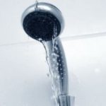 Showerhead with silver finish, featuring flowing water streams in a clean aesthetic for plumbing maintenance insights.