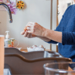 Person cracking an egg in a tidy kitchen, focusing on home cooking for Allore's Plumbing Services.